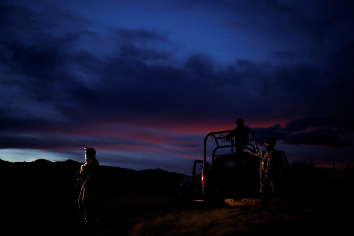 Soldiers assigned to the National Guard keep watch while escorting a caravan of vehicles with relatives and friends arriving for the funerals of slain members of the Mexican American Mormon families, in Bavispe, Sonora state, Mexico, on Nov. 6, 2019. (Reuters/Jose Luis Gonzalez)