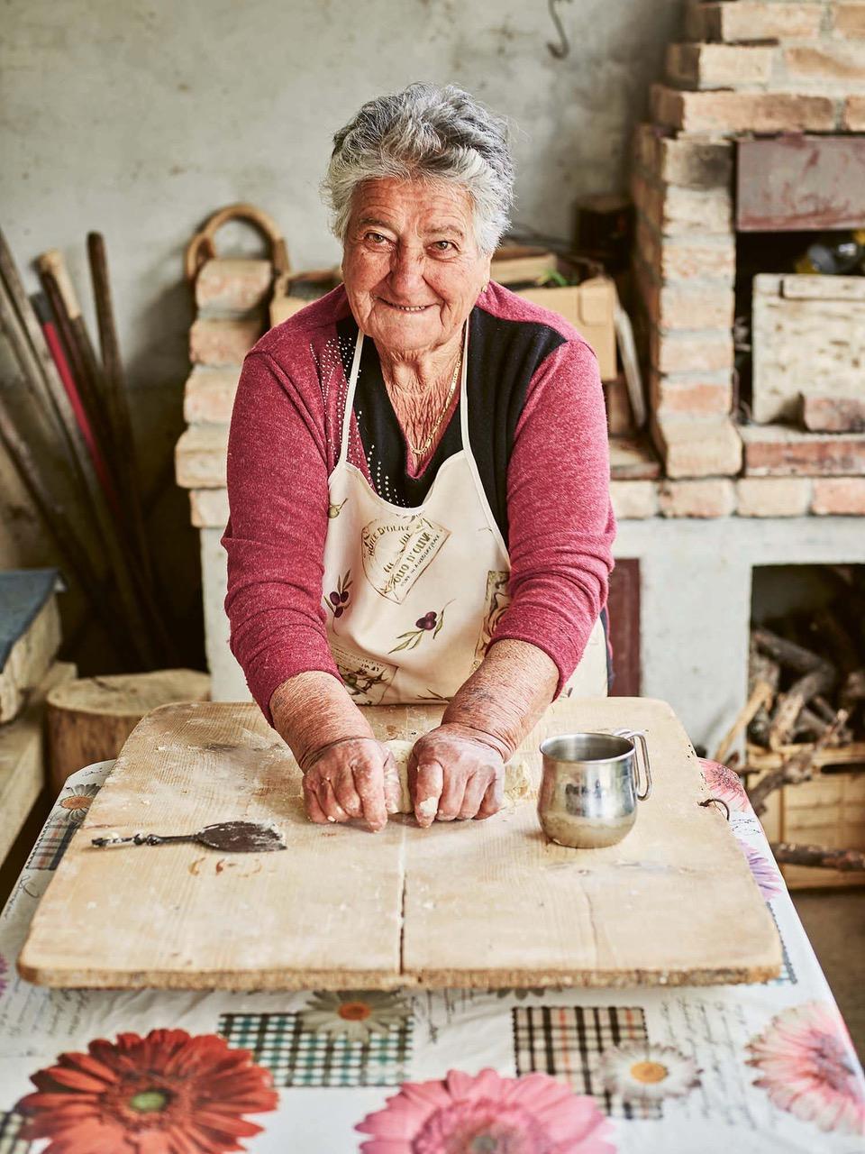 Maria, a farmer from Basilicata, kneads dough to make raschiatelli, a local pasta she has been making since she was 8-years-old. She'll dress the pasta with homemade olive oil and peperone di Senise from her garden. (Emma Lee)
