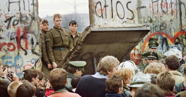 West Berliners crowd in front of the Berlin Wall early Nov. 11, 1989, as they watch East German border guards demolishing a section of the wall. (Gerard Malie/AFP via Getty Images)