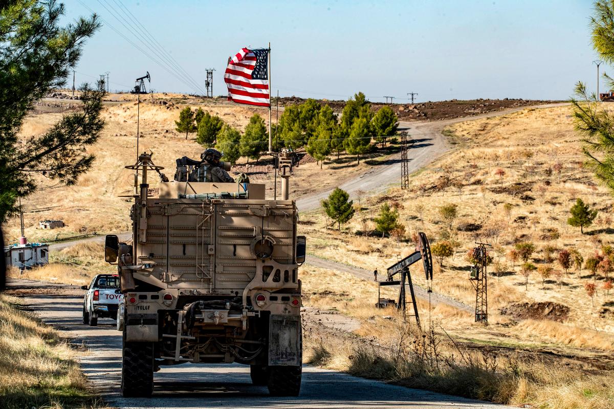 United States military armored vehicles drive in a patrol past an oil well in Rumaylan in Syria's northeastern Hasakeh province on Nov. 6, 2019. (Delil Souleiman/AFP via Getty Images)