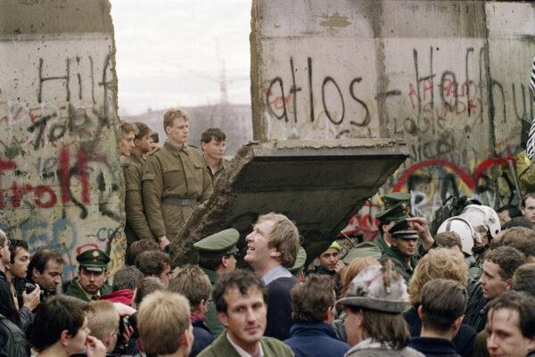  West Berliners crowd in front of the Berlin Wall early Nov. 11, 1989, as they watch East German border guards demolishing a section of the wall. (Gerard Malie/AFP via Getty Images)