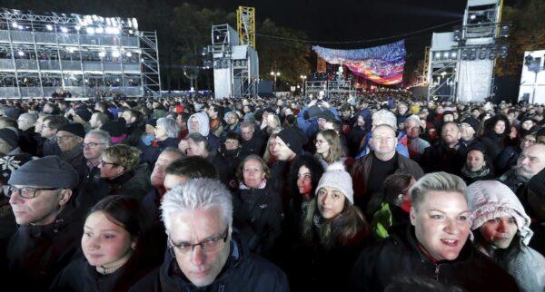 Visitors stay in front of the Brandenburg Gate as they attend stage presentations to celebrate the 30th anniversary of the fall of the Berlin Wall in Berlin, Germany, on Nov. 9, 2019. (Michael Sohn/AP Photo)