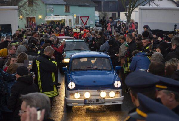People welcome the legendary GDR cars Trabant (Trabi) and celebrate during a symbolic wall opening at the 30th anniversary of falling wall in the outdoor area of the German-German museum in Moedlareuth, Germany, on Nov. 9, 2019. (Jens Meyer/AP Photo)