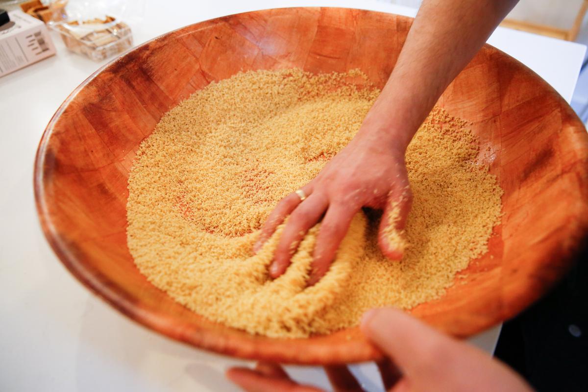 Rolling the semolina into tiny beads of couscous. (Samira Bouaou/The Epoch Times)