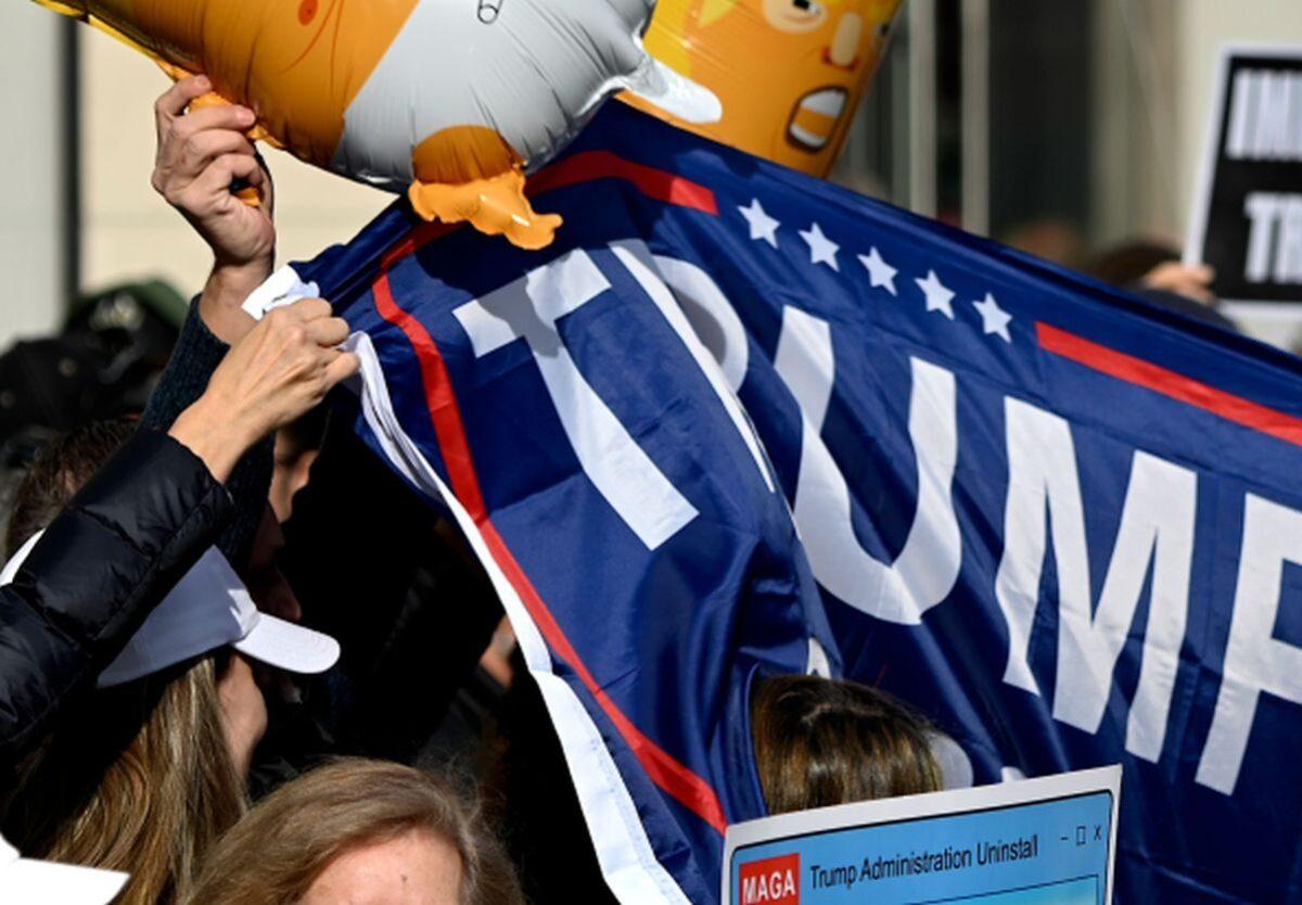 People hold signs during a rally against President Donald Trump, near the Veterans Day Parade in New York City on Nov 11, 2019. (Johannes Eisele/AFP via Getty Images)