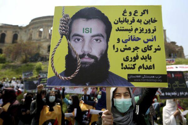 A protester holds a poster on April 26, 2016, that reads in Persian, "If Ghani and Abdullah do not betray the terrorist attacks' victims, they should execute Anas Haqqani and the other terrorist leaders who have been arrested" during a demonstration in Kabul, Afghanistan. (Rahmat Gul/AP Photo)