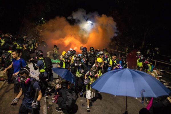 Protesters (front, L) and journalists react after police fired tear gas at CUHK on Nov. 12, 2019.(Dale De La Rey/AFP via Getty Images)