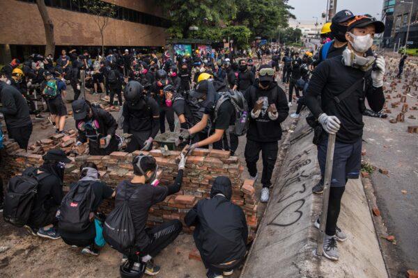Protesters build a wall to block a road at The Hong Kong Polytechnic University, in Hong Kong on November 14, 2019. (DALE DE LA REY/AFP via Getty Images)