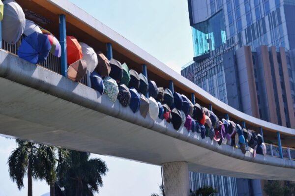 Protesters hold umbrella on a bridge at the Polytechnic University during a face-off with the police in Hong Kong, on Nov. 17, 2019. (Sung Pi Lung/The Epoch Times)
