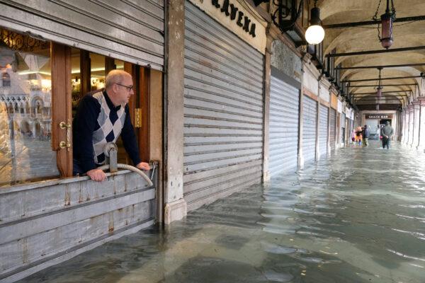 A man stands inside is store in St. Mark’s Square after days of severe flooding in Venice, Italy, on Nov. 17, 2019. (Manuel Silvestri/Reuters)