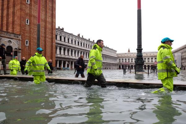 Workers walk in St. Mark’s Square after days of severe flooding in Venice, Italy, on Nov. 17, 2019. (Manuel Silvestri/Reuters)