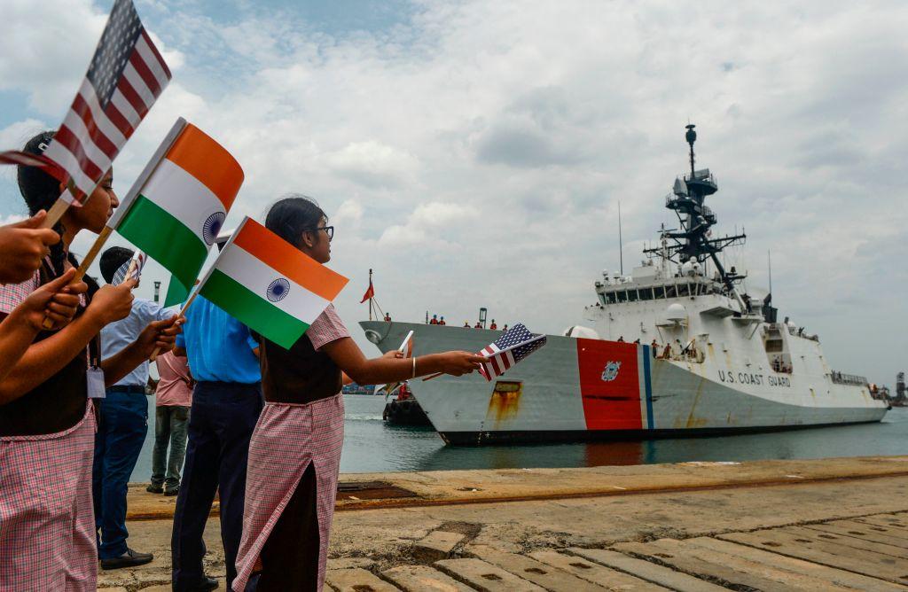 Students wave Indian and U.S. national flags during a welcoming ceremony for United States Coast Guard (USCG) cutter Ship 'Stratton' anchored at Chennai port on Aug. 23, 2019. (Arun Sankar/AFP via Getty Images)