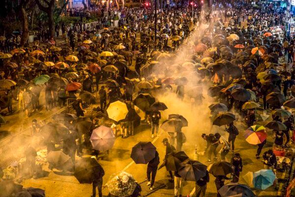 Protesters react as police fire tear gas while they attempt to march towards Hong Kong Polytechnic University on Nov. 18, 2019. (Dale de la Rey/AFP via Getty Images)