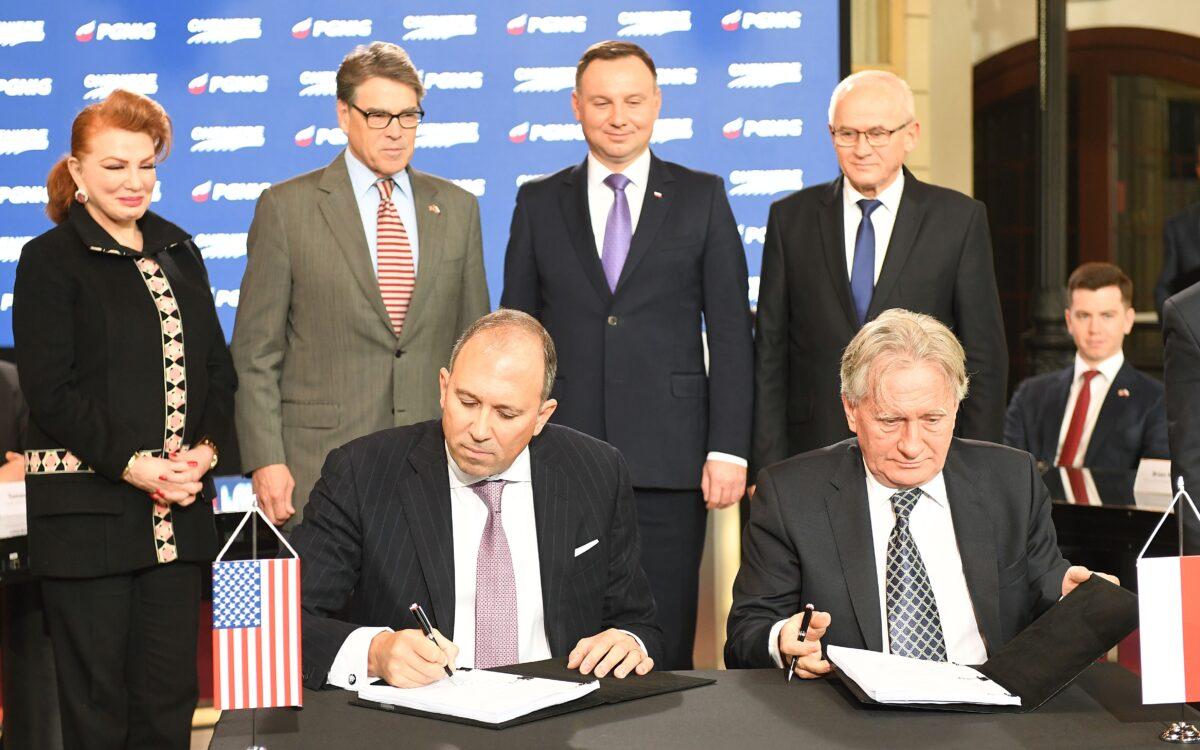 Cheniere Energy Vice President Anatol Feygin (L) and PGNiG CEO Piotr Wozniak sign a 24-year deal in Warsaw in 2018 for Cheniere to deliver liquefied natural gas (LNG) to Poland as (L-R) then-U.S. Poland Ambassador to Georgette Mosbacher, then-US Energy Secretary Rick Perry, Polish President Andrzej Duda, and Poland's Energy Minister Krzysztof Tchorzewski look on. (Janek SKARZYNSKI / AFP via Getty Images)