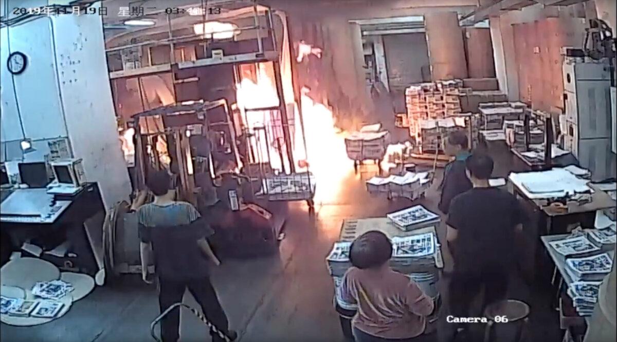 Staff at the print shop that prints the Hong Kong edition of The Epoch Times react to a fire started by four masked men on Nov. 19, 2019.