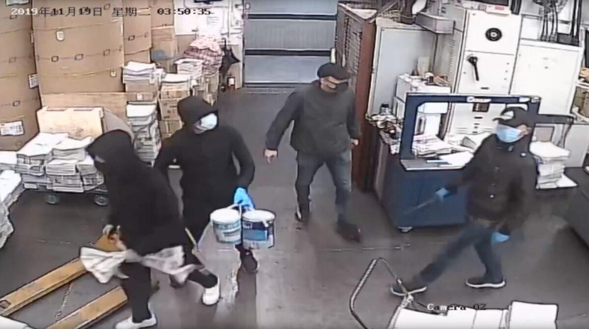 Four masked men enter the Hong Kong Epoch Times print shop before threatening workers and setting a fire on Nov. 19, 2019.