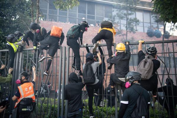 Protesters climb over fences during an attempt to leave the Hong Kong Polytechnic University in Hong Kong on Nov.18, 2019. (Anthony Kwan/Getty Images)
