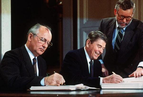 Soviet leader Mikhail Gorbachev (L) and U.S. President Ronald Reagan sign a treaty on Dec. 8, 1987, at the Washington summit, eliminating U.S. and Soviet intermediate-range and shorter-range nuke missiles. (-/AFP via Getty Images)