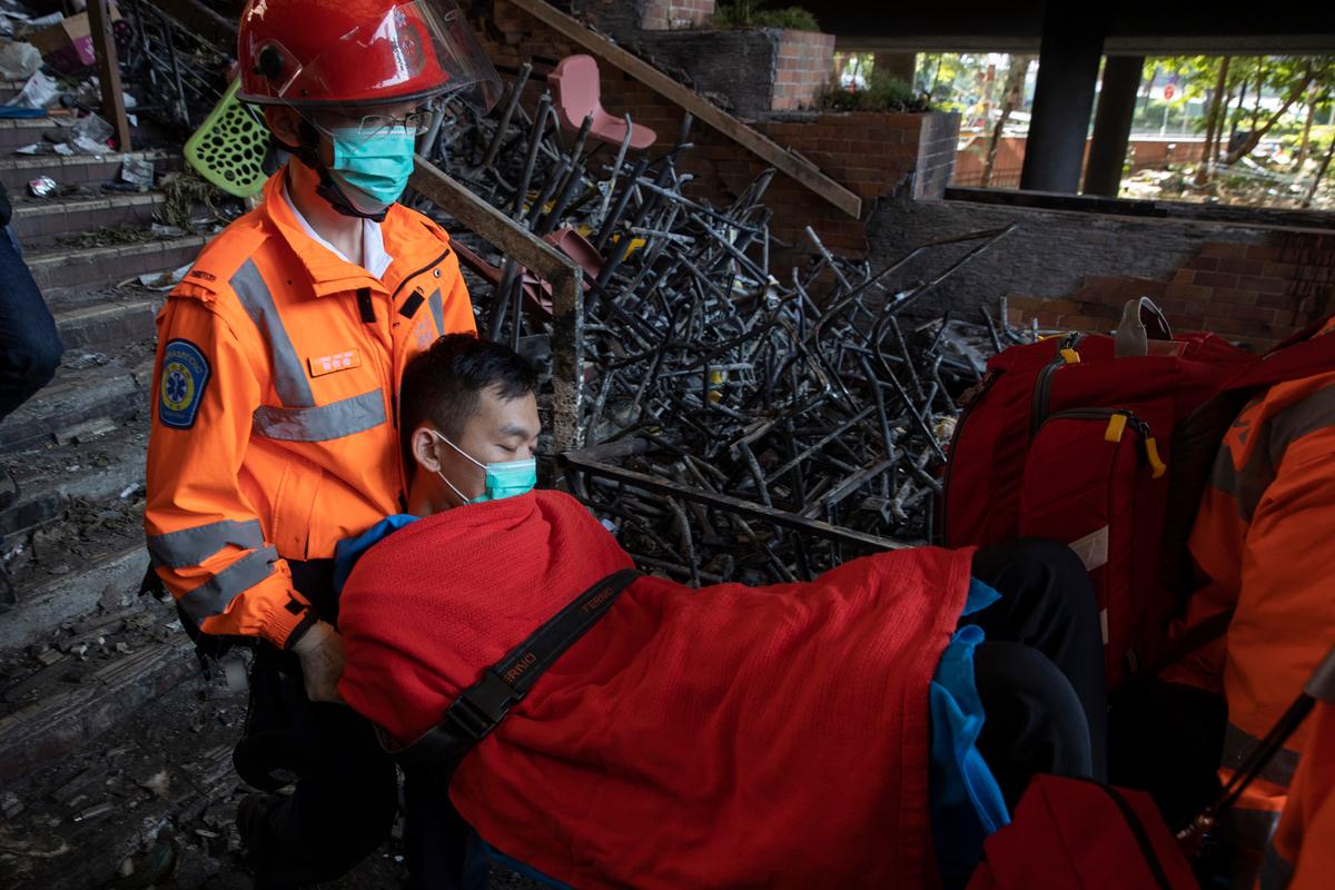 A man is evacuated by medics past charred debris from the Polytechnic University in Hong Kong on Nov. 20, 2019. (Ng Han Guan/AP)