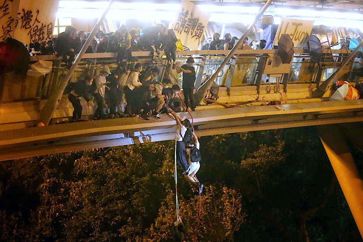Protesters trapped inside Hong Kong Polytechnic University abseil onto a highway and escape before being forced to surrender during a police besiege of the campus in Hong Kong on Nov. 18, 2019. (HK01/Handout via Reuters)
