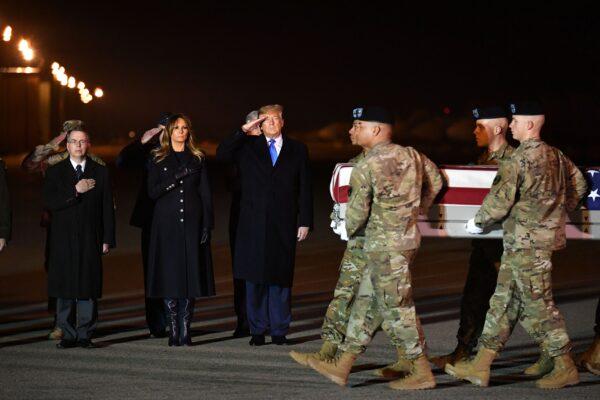 (L-R) Deputy Secretary of Defense David Norquist, First Lady Melania Trump and President Donald Trump watch as the remains of Chief Warrant Officer 2 David C. Knadle are carried during a dignified transfer at Dover Air Force Base in Dover, Del., on Nov. 21, 2019. (Mandel Ngan/AFP via Getty Images)