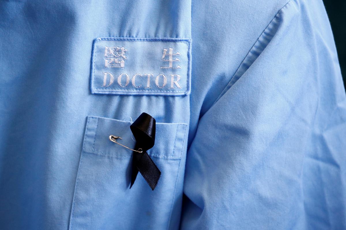 A doctor wears a protest ribbon during a picket by medical staff denouncing what they say is police brutality during recent pro-democracy protests, at Queen Elizabeth Hospital in Hong Kong, China on Aug. 13, 2019. (Thomas Peter/Reuters)