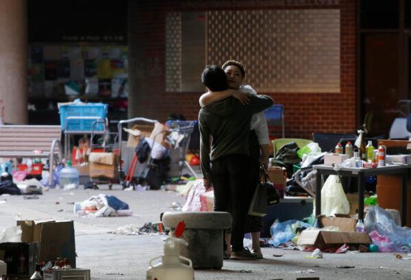 A protester hugs a social worker inside the campus of Hong Kong Polytechnic University in Hong Kong on Nov. 22, 2019. Most of the protesters who took over the university last week have left, but an unknown number has remained inside for days, hoping somehow to avoid arrest. (AP Photo/Achmad Ibrahim)