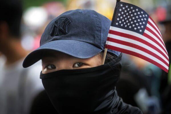 A protester with a US national flag sticking out from her mask takes part in a march from Chater Garden to the US Consulate in Hong Kong on Sept. 8, 2019. (Vivek Prakash/AFP via Getty Images)