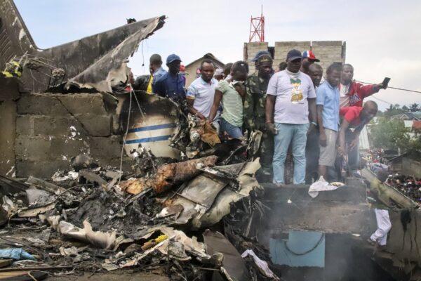 Rescuers and onlookers gather amidst the debris of an aircraft operated by private carrier Busy Bee which crashed in Goma, Congo on Nov. 24, 2019. (Justin Kabumba/AP Photo)