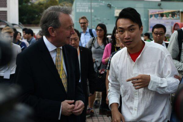 Pro-democracy district council candidate Jimmy Sham (R) talks with British politician David Alton (L) at a public housing estate during district council elections in the Sha Tin district of Hong Kong on Nov. 24, 2019. (Philip Fong/AFP via Getty Images)