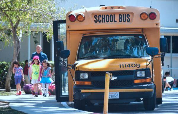 Children walk past a school bus in Monterey Park, Calif., on April 28, 2017. (Frederic J. Brown/AFP via Getty Images)