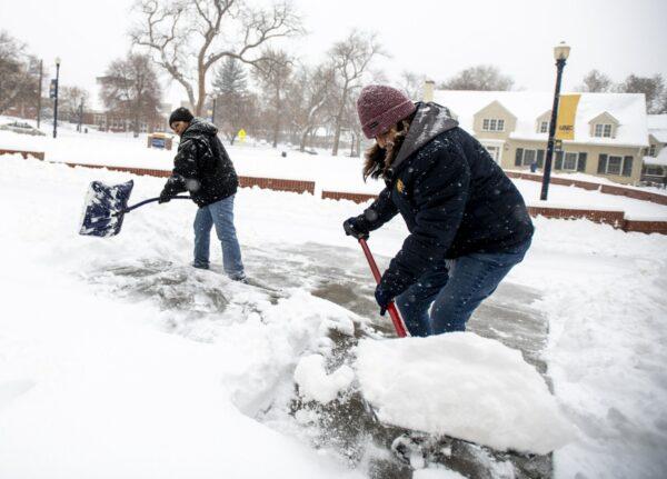 University of Northern Colorado facilities management staff Francis Garza (L) and Tina Longoria shovel snow from the steps and entranceway to Sabin Hall during a winter storm in Greeley, Colo., on Nov. 26, 2019. (Alex McIntyre/The Greeley Tribune via AP)