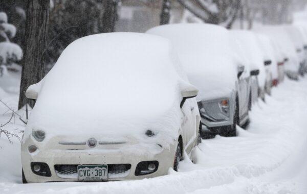 A long line of parked vehicles sits covered with snow as a snowstorm sweeps in over the region in Denver, Colo., on Nov. 26, 2019. (David Zalubowski/AP Photo)