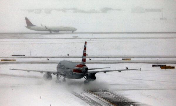 An American Airlines jet taxis down a snow-covered runway after a pre-Thanksgiving holiday snowstorm caused more than 460 flight cancellations at Denver International Airport, Colo., on Nov. 26, 2019. (Bob Strong/Reuters)