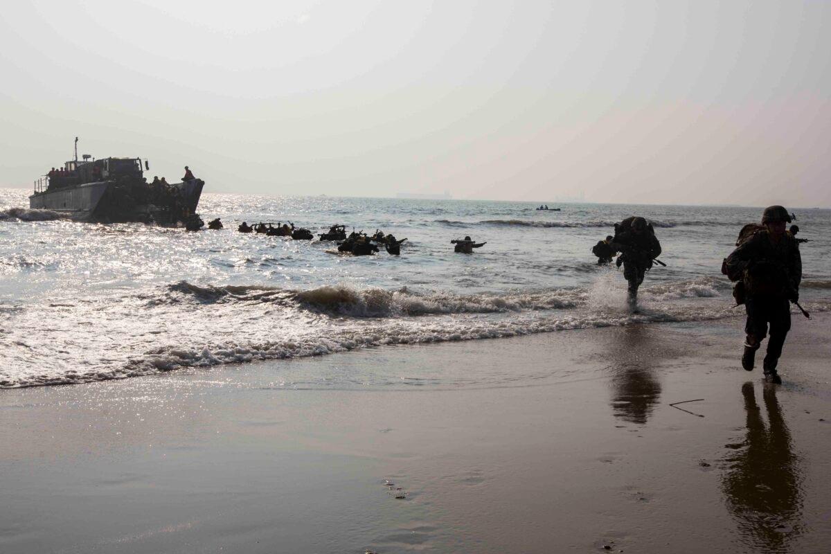 U.S. Marines currently under the 4th Marine Regiment, 3rd Marine Division, and members of the Indian military run to shore on Kakinada Beach, India, on Nov. 19, 2019. (U.S. Marine Corps photo by Lance Cpl. Christian Ayers)