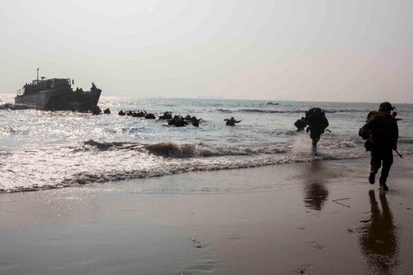 U.S. Marines currently under the 4th Marine Regiment, 3rd Marine Division, and members of the Indian military run to shore on Kakinada Beach, India, on Nov. 19, 2019. (Lance Cpl. Christian Ayers/U.S. Marine Corps)