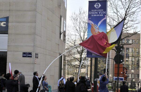 Chinese nationals living in Belgium try to cover with a Chinese and a Belgian flag an advertisement for Shen Yun Performing Arts at the National Theatre in Brussels on March 31, 2014 (Georges Gobet/AFP via Getty Images)