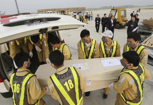 Airport personnel load a coffin into an ambulance at the Noi Bai airport on Nov. 27, 2019 in Hanoi, Vietnam. (Vietnam News Agency via AP)
