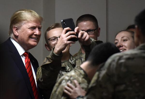 U.S. President Donald Trump poses for selfies during a Thanksgiving dinner with U.S. troops at Bagram Airfield during a surprise visit in Afghanistan on Nov. 28, 2019. (Olivier Douliery/AFP via Getty Images)
