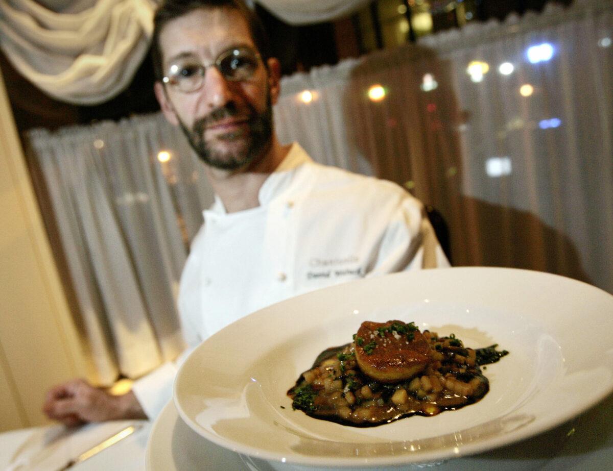 David Waltuck, chef at Chanterelle restaurant in New York City, holds a dish with a piece of foie gras on potato risotto, on Dec. 1, 2006. (Stan Honda/AFP via Getty Images)