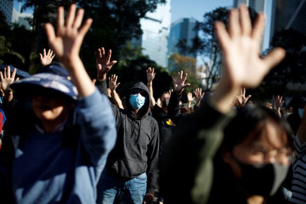 People raise their hands as they sing the protest anthem "Glory to Hong Kong" during a protest in the Central district of Hong Kong on Nov. 30, 2019. (Thomas Peter/Reuters)