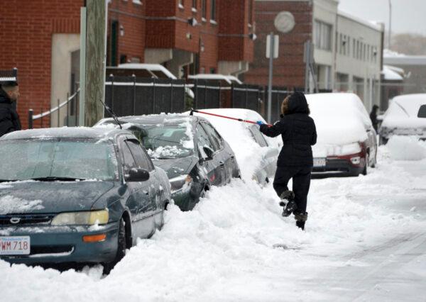 A woman clears snow from a car on Grove Street in Springfield's North End neighborhood on Dec. 2, 2019. (Don Treeger/The Republican via AP)