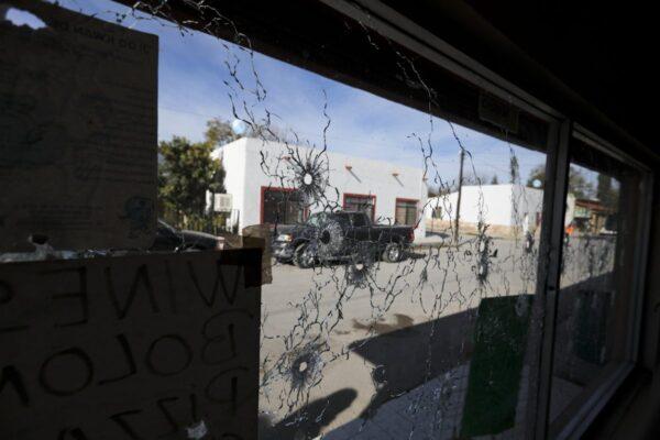 A shop's windows are riddled with bullet holes near City Hall after a gun battle in Villa Union, Mexico, on Dec. 2, 2019. (Eduardo Verdugo/AP Photo)
