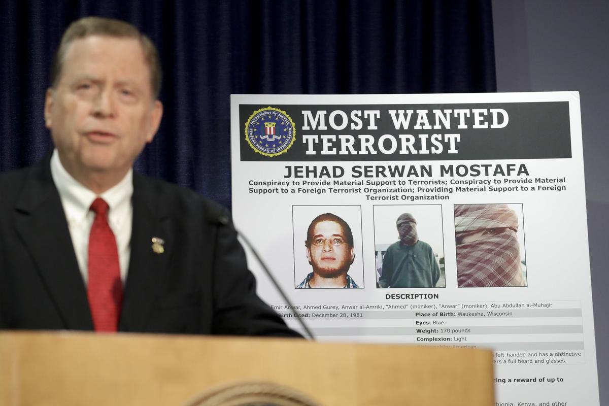 U.S Attorney Robert Brewer speaks in front of an FBI poster depicting Jehad Serwan Mostafa during a news conference in San Diego, California on Dec. 2, 2019. (Gregory Bull/AP Photo)