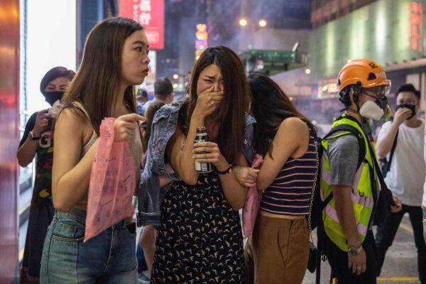 Pedestrians react after police fired tear gas to disperse pro-democracy protesters in the Mong Kok district in Hong Kong on Oct. 27, 2019. (Dale De La Rey/AFP via Getty Images)