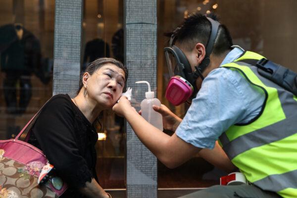 A woman is treated after police fired tear gas to disperse protesters in the Central district in Hong Kong on Nov. 12, 2019. (Dale De La Rey/AFP via Getty Images)