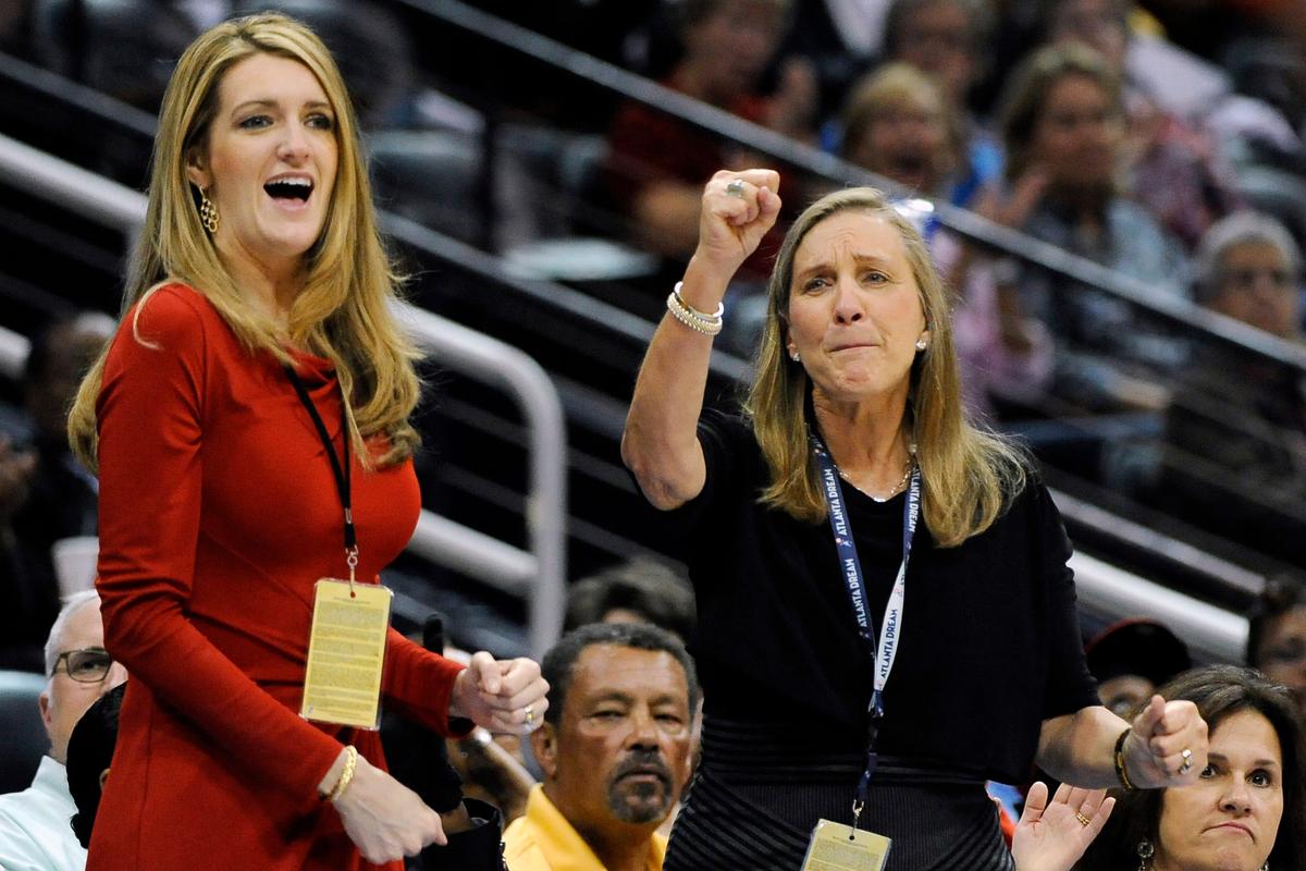 Mary Brock, right, and Kelly Loeffler cheer from their courtside seats as the Atlanta Dream basketball team plays in the second half of their WNBA basketball game, in Atlanta on Sept. 6, 2011. (David Tulis, File/AP Photo)