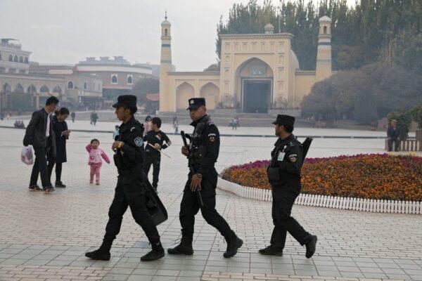 Uyghur security personnel patrol near the Id Kah Mosque in Kashgar in western China's Xinjiang region, on Dec. 4, 2019. (AP Photo/Ng Han Guan)