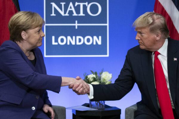 President Donald Trump shakes hands with German Chancellor Angela Merkel during the NATO summit at The Grove, in Watford, England on Dec. 4, 2019. (Evan Vucci/ AP Photo)