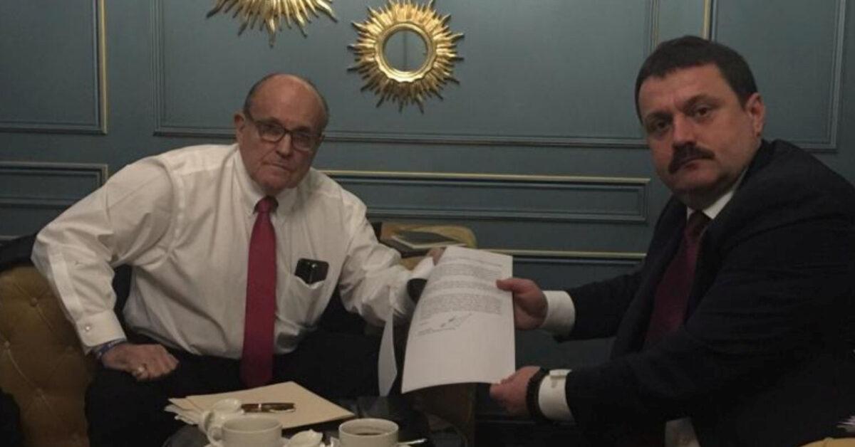 Ukrainian lawmaker Andriy Derkach and President Donald Trump's lawyer Rudy Giuliani show a document during a meeting in Kyiv, Ukraine, in this undated picture obtained from social media. (Andriy Derkach via Reuters)